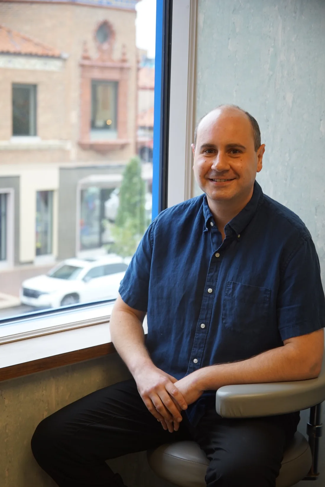 Dr. Eli Wolkoff seated beside a window in his Country Club Plaza office